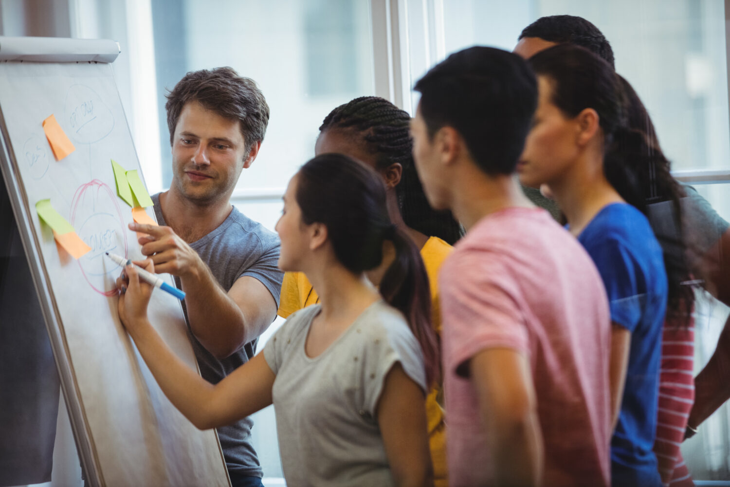 Business executive explaining her colleagues on whiteboard